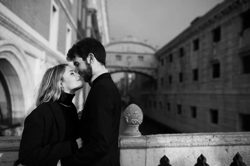 In bianco e nero, Nicole e Davide si baciano sul ponte, dietro di loro il Ponte dei Sospiri
